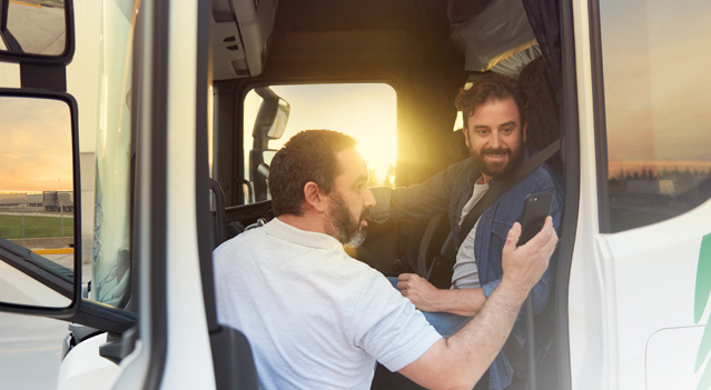 Dos conductores mirando el buscador de rutas en su celular