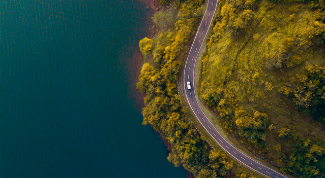 Vehiculo en una ruta rodeada de naturaleza: transporte sustentable 